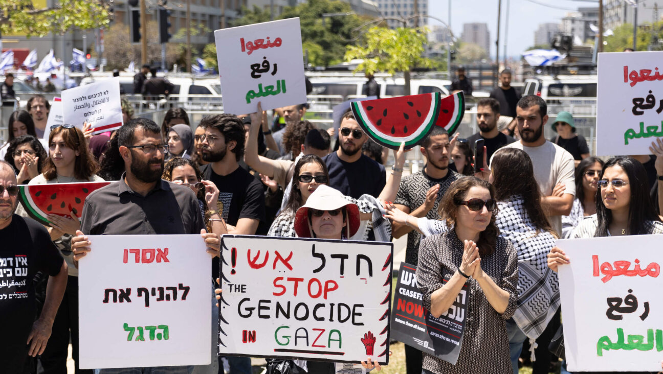 Pro-Palestinian activists hold signs during a rally to mark Nakba Day at Tel Aviv University on May 15.