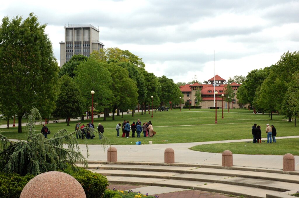 Landscape of a quad with trees on the side and a red building in the distance