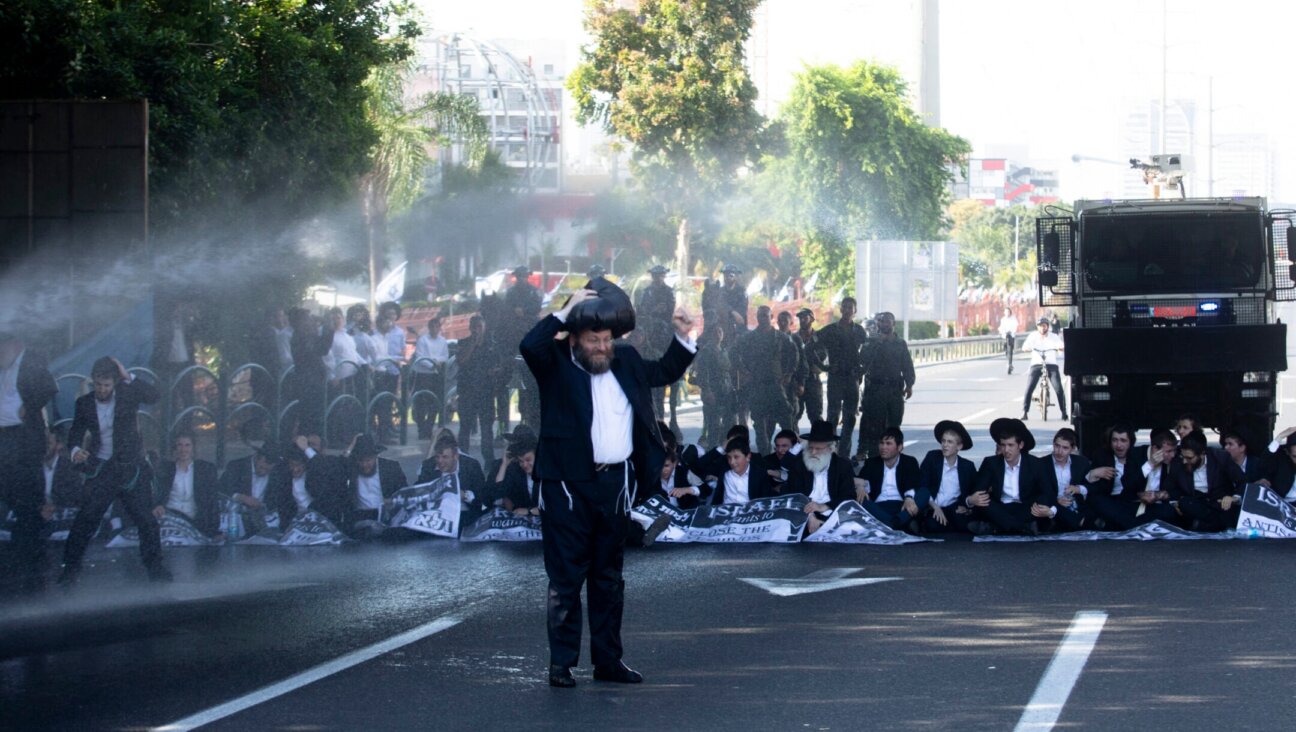 Police officers use water cannons as haredi Orthodox Jewish men block a main highway during a protest against drafting into the Israeli army on June 2, 2024 in Bnei Brak, Israel. (Amir Levy/Getty Images)