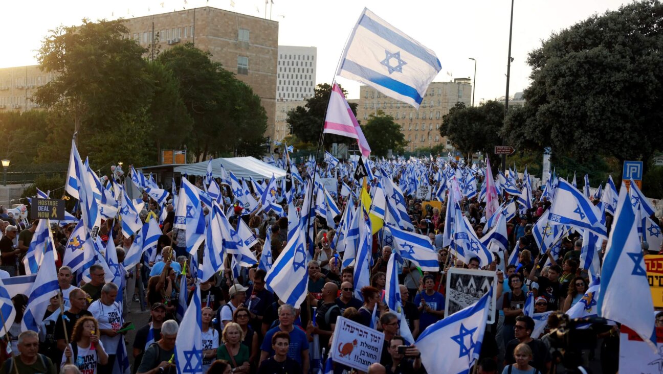 Israelis wave their national flag during an anti-government rally calling for early elections outside the Knesset June 18.