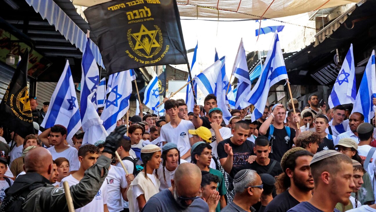 Demonstrators waving the Israeli flag and the banner of the far-right Jewish group Lehava gather during the Israeli “flags march” to mark Jerusalem Day in the Old City on May 29, 2022. (Hazem Bader/AFP via Getty Images)