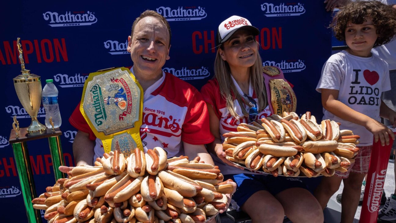 Joey Chestnut, left, and Miki Sudo hold 63 and 40 hot dogs respectively after winning the Nathan's Famous 4th of July 2022 hot dog eating contest on Coney Island. 