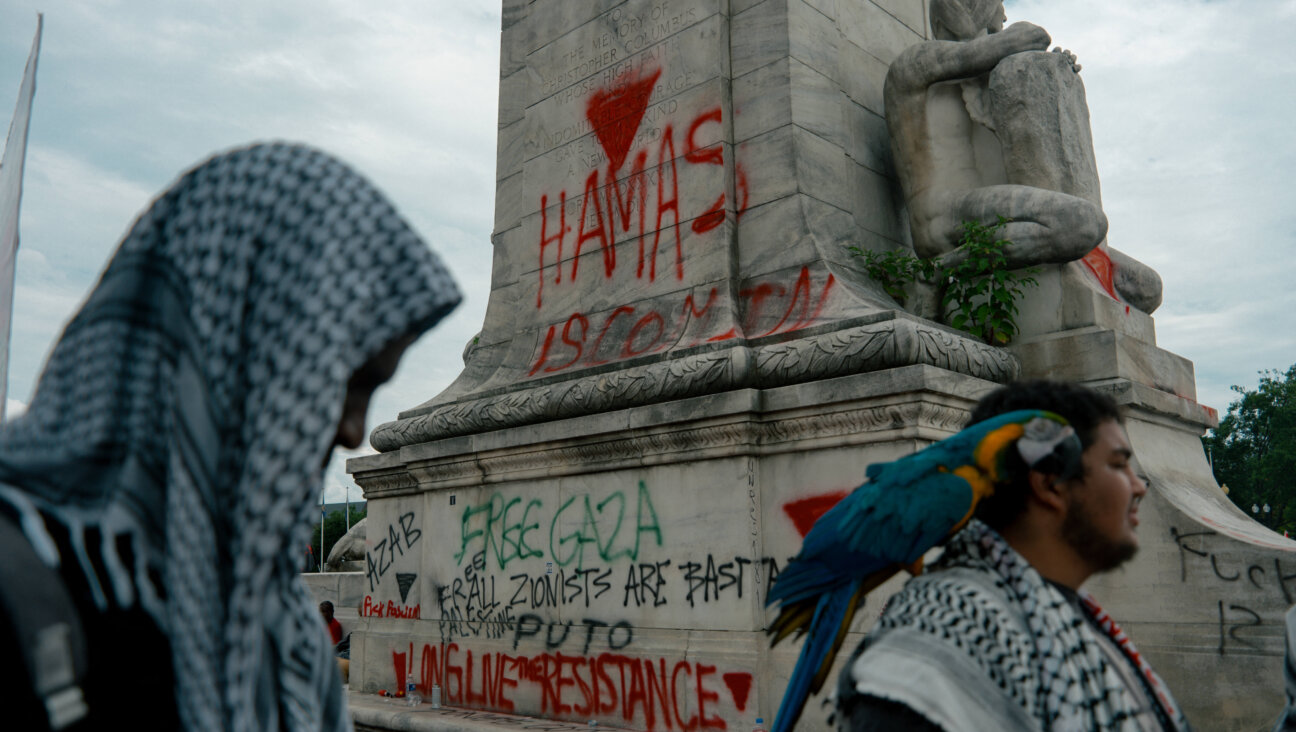 Pro-Palestinian protesters spray paint a message outside the Capitol.