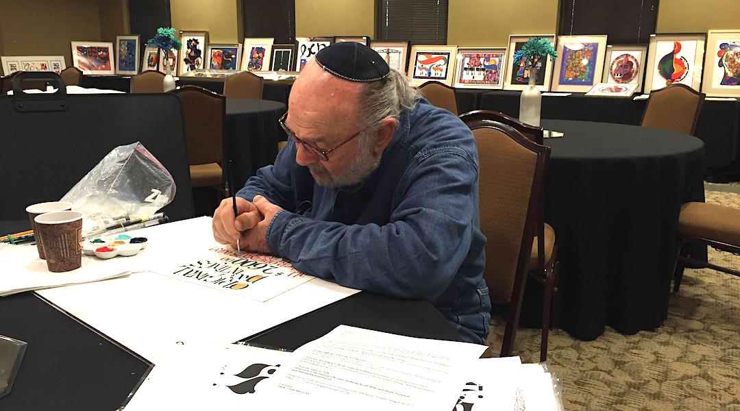 Mordechai Rosenstein, seen in 2014 at a sale of his works, combined bright colors and stylized Hebrew letters for pieces that hang in countless homes, offices and synagogues. (Courtesy Rosenstein Arts, via Facebook)