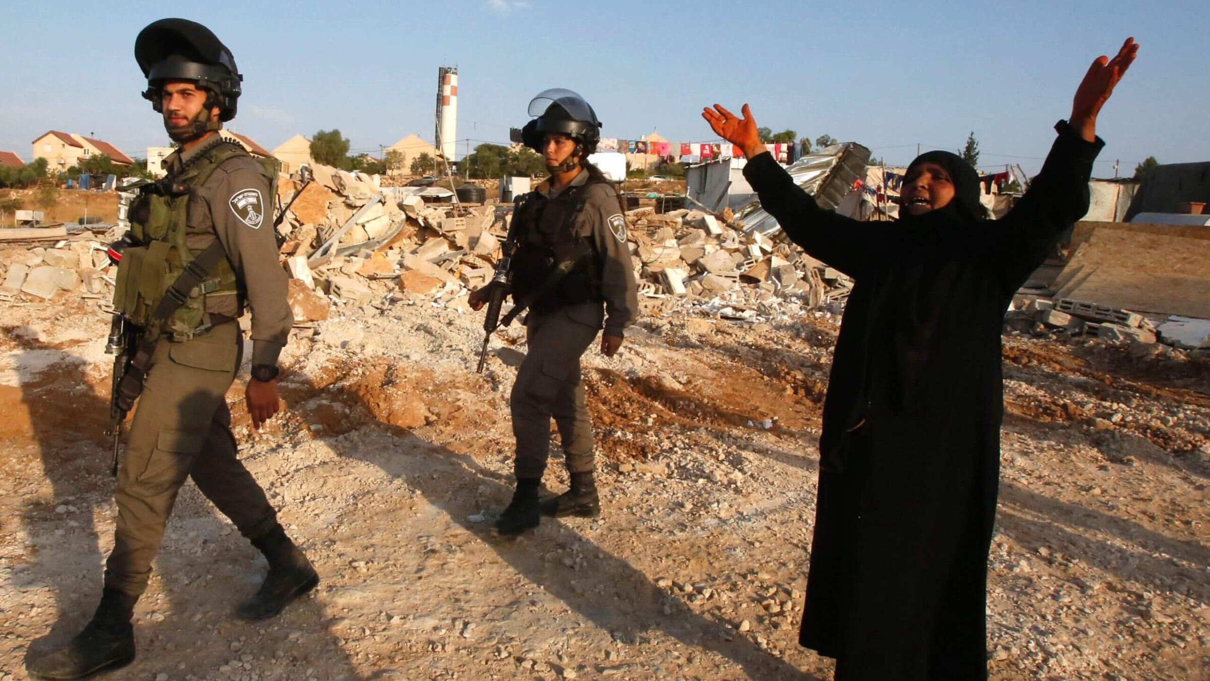 A Palestinian woman reacts as Israeli bulldozers destroy her home and a community center in the West Bank village of Umm al-Kheir, August 24, 2016.