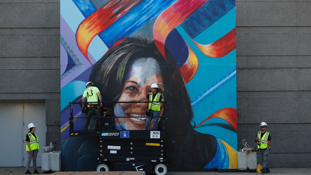 Workers construct a mural of Democratic presidential nominee Vice President Kamala Harris outside of the United Center, Chicago, Aug. 16, 2024. (Kevin Dietsch/Getty Images)