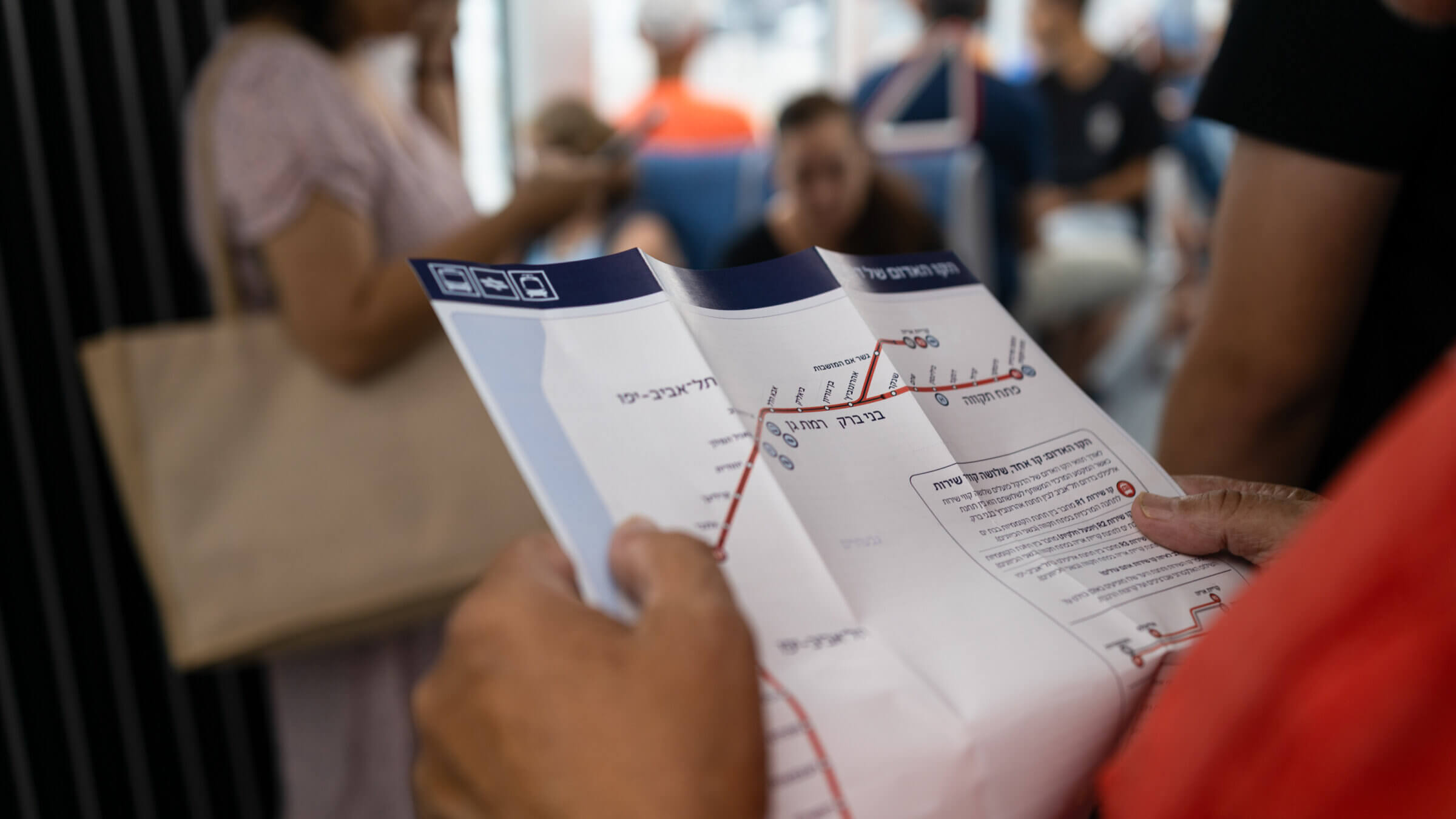 A passenger holds a map of Tel Aviv's light-rail system.