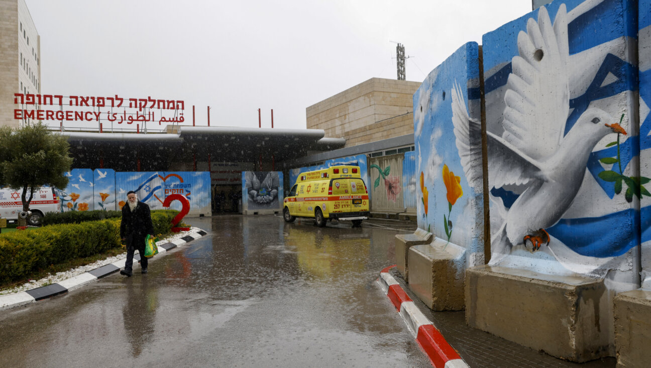 A man walks past murals outside the Ziv Hospital in the northern Israeli city of Safed in January. Jewish federations across North America have raised hundreds of millions of dollars to help Israel recover from the Oct. 7 terrorist attacks, but many of those dollars remain unspent.