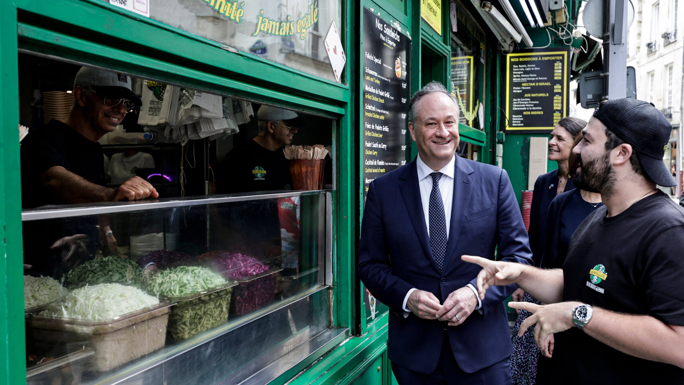 US second gentleman Doug Emhoff speaks with the employee of a restaurant at the site of a deadly 1982 antisemitic attack.