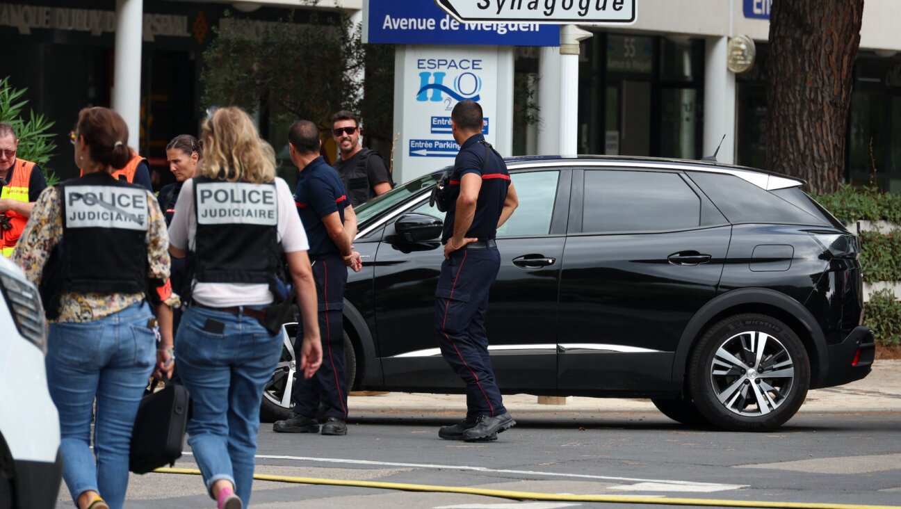 French judicial police officers walk past firefighters following a fire and explosion of cars at a synagogue in La Grande-Motte, south of France, Aug. 24, 2024. (Pascal Guyot/AFP via Getty Images)