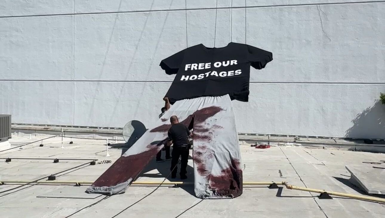 Artist Tomer Peretz works on an installation planned for a Hostages Square replica near the Democratic National Convention. (Michael Cannon)