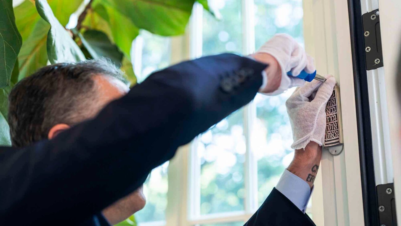 Second Gentleman Doug Emhoff affixes a mezuzah at the vice president's residence in Washington, D.C., in 2021. 