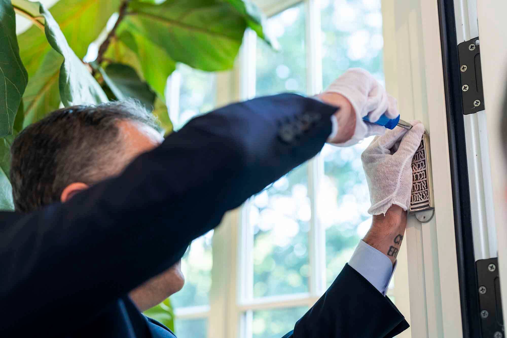 Second Gentleman Doug Emhoff affixes a mezuzah at the vice president's residence in Washington, D.C., in 2021. 