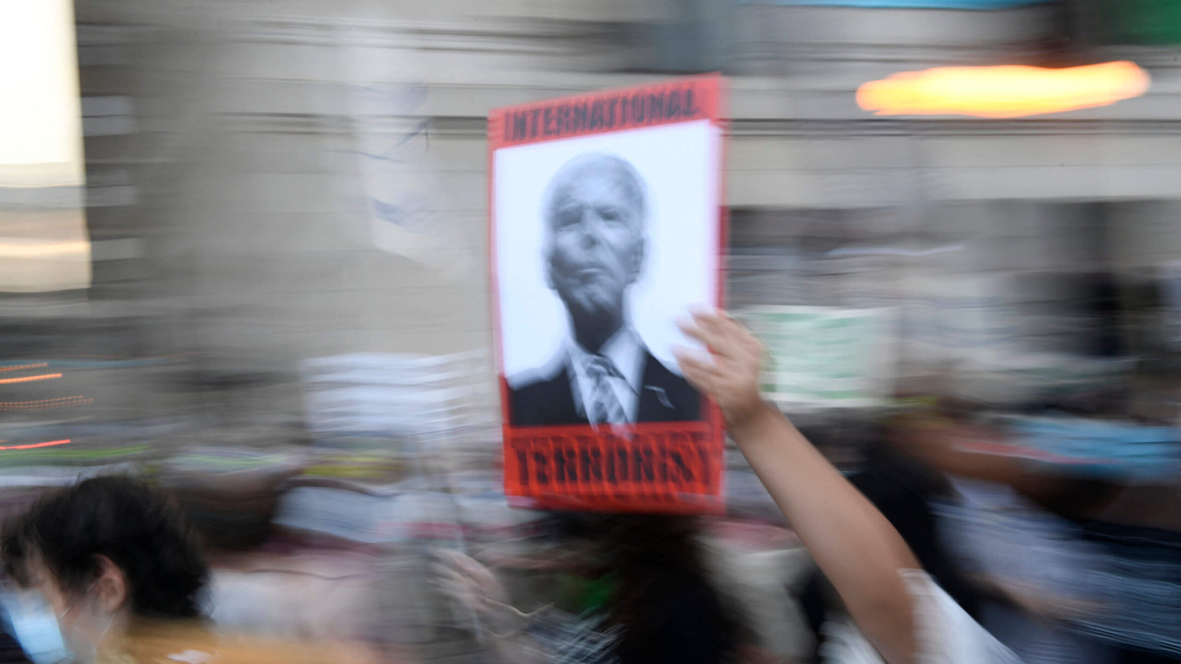 A protester holds a sign reading "International terrorist" with a portrait of President Joe Biden during a protest to demand reproductive justice, defend the rights of trans and queer people and demand a ceasefire in Gaza on the eve of the Democratic National Convention, Chicago, on Aug. 18. 