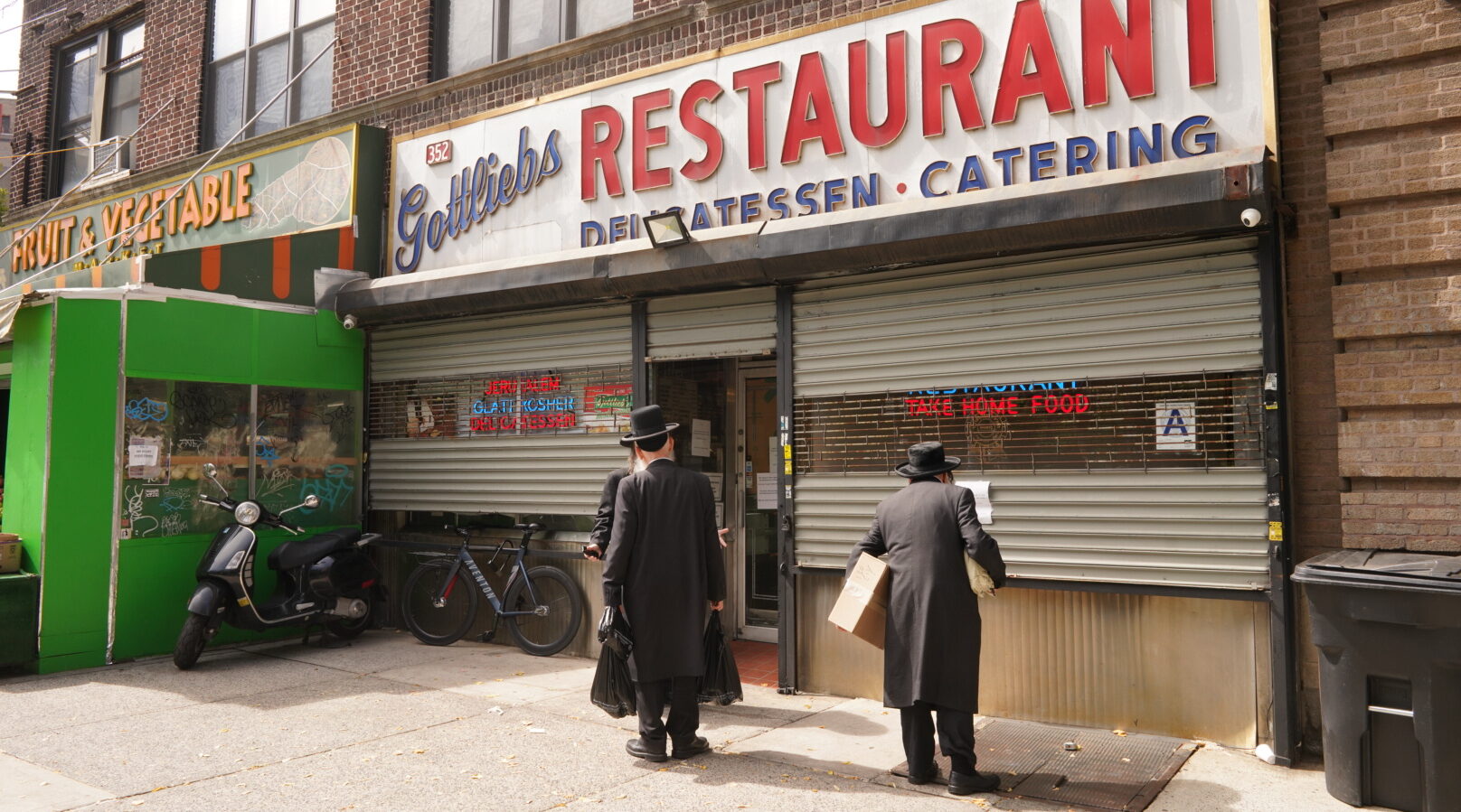 Passersby read notices for the funeral of the owner of Gottlieb’s Restaurant in Williamsburg, Sept. 19, 2024. (Luke Tress)