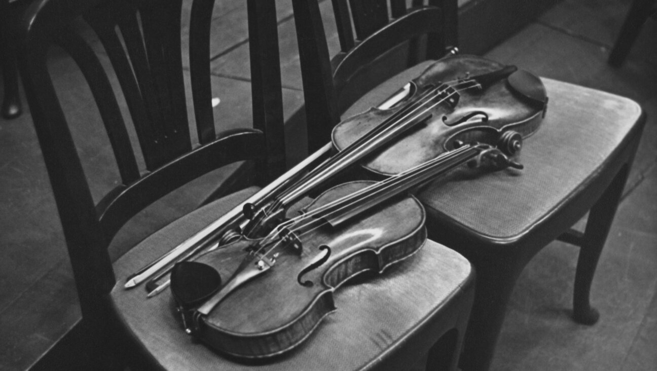 A pair of violins resting side by side backstage.