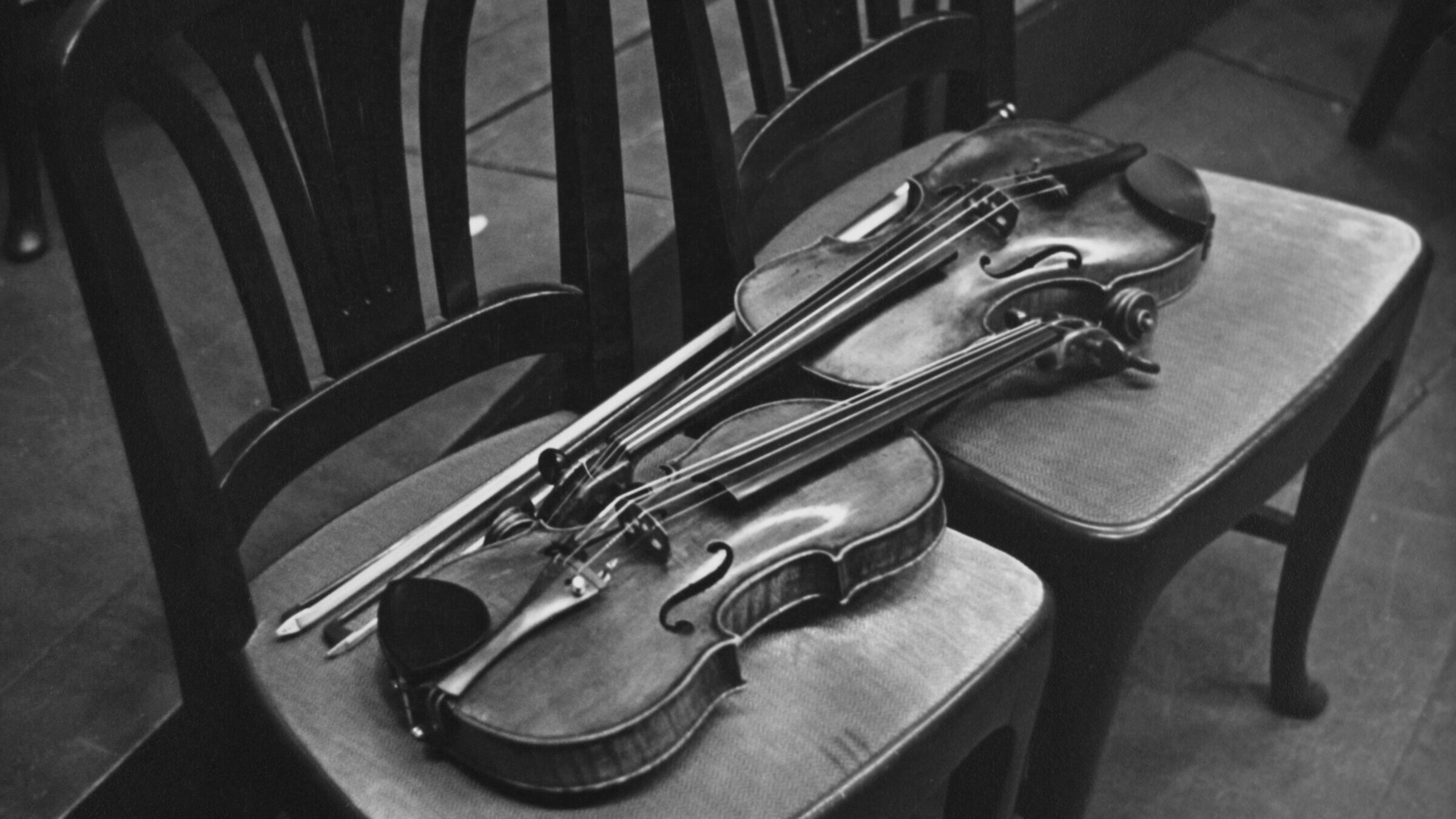 A pair of violins resting side by side backstage.