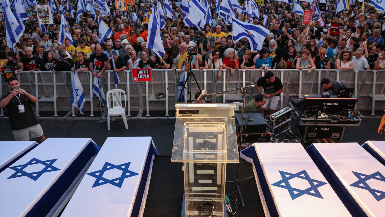 Protesters lift flags and placards next to symbolic coffins representing six Israeli hostages whose bodies were recovered from the Gaza Strip, during an anti-government rally calling for the release of the captives held by Palestinian militants in Gaza since October, in Tel Aviv on Sept. 1, 2024.