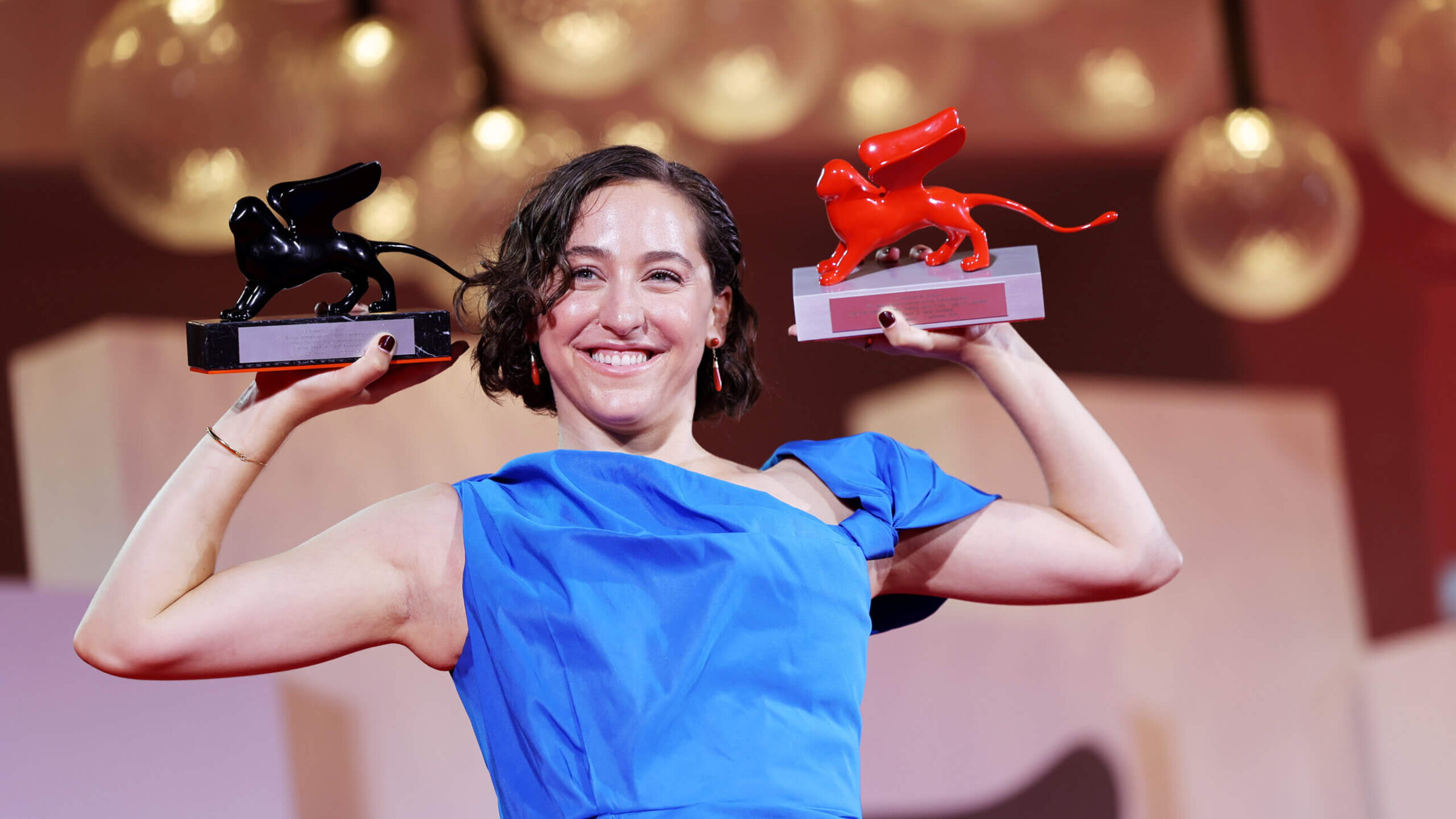 Sarah Friedland posing with her awards at the Venice Film Festival.