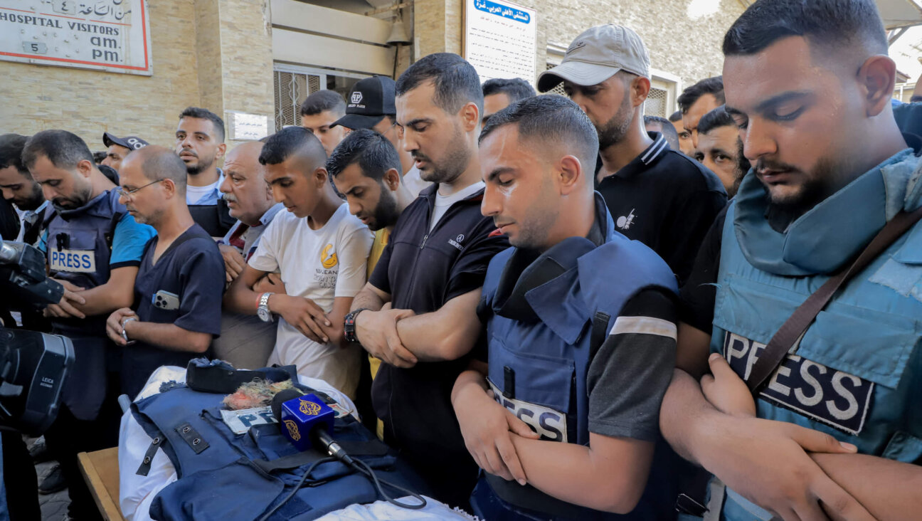 Mourners and colleagues surround the bodies of Al-Jazeera Arabic journalist Ismail al-Ghoul and cameraman Rami al-Refee, killed in an Israeli strike during their coverage of Gaza's Al-Shati refugee camp, on July 31. 