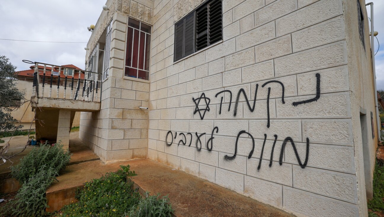 An anti-Palestinian slogan in Hebrew, which reads “Revenge” and “Death to Arabs” is seen on a Palestinian home after a reported attack by Israeli settlers in the village of Turmus Aiya near Ramallah in the West Bank, on Feb. 18, 2024. (Jaafar Ashtiyeh/AFP)