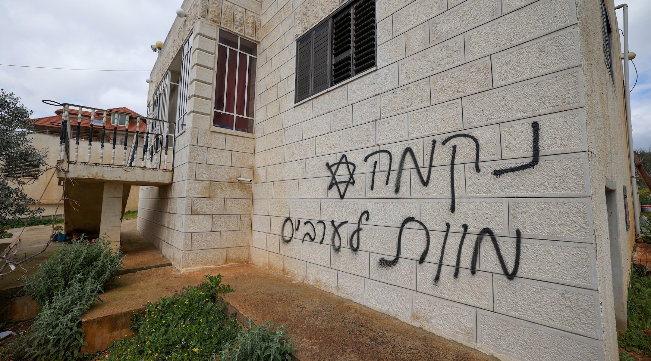 An anti-Palestinian slogan in Hebrew, which reads “Revenge” and “Death to Arabs” is seen on a Palestinian home after a reported attack by Israeli settlers in the village of Turmus Aiya near Ramallah in the West Bank, on Feb. 18, 2024. (Jaafar Ashtiyeh/AFP)