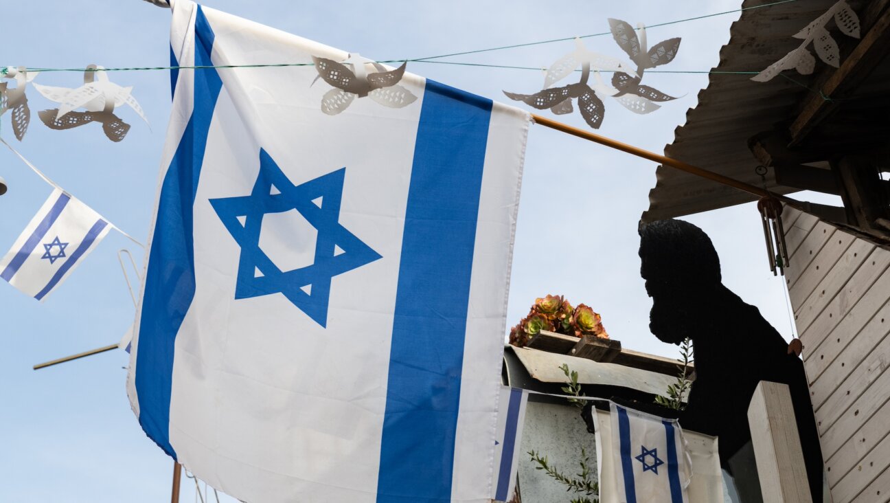 A silhouette of Theodor Herzl, the founder of modern Zionism, is displayed near a flag of the state of Israel on a building in Jerusalem. (Yehoshua Halevi/Getty Images)