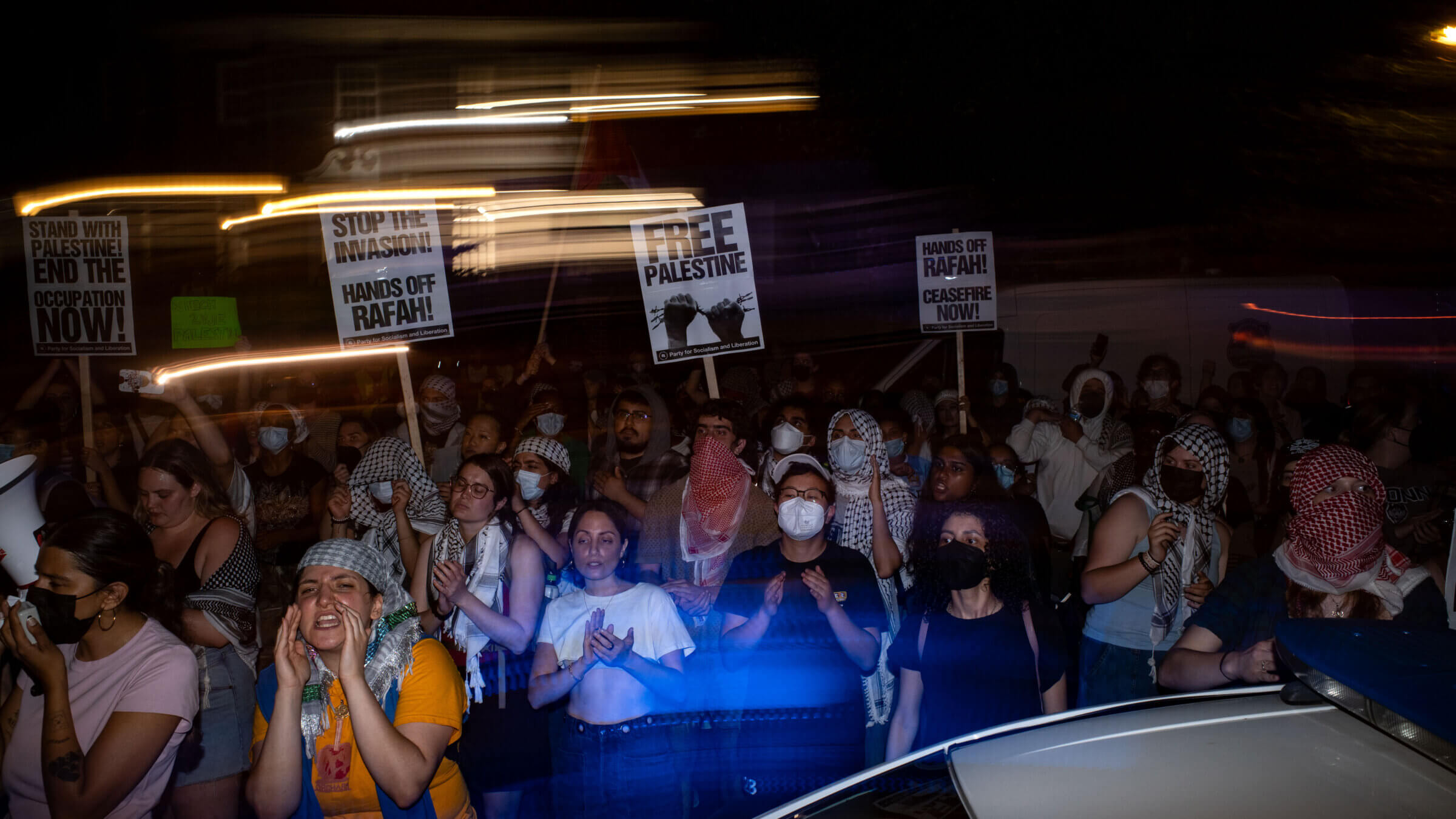 Police are posted near the house of George Washington University President Ellen Granberg in May as pro-Palestinian protesters rally in the street after a march.