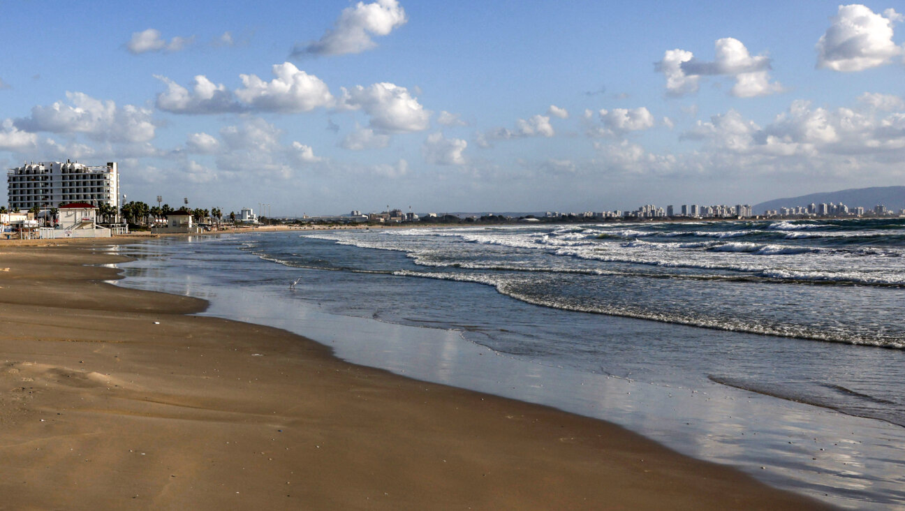 An empty beach overlooking the Mediterranean sea in Acre, just across from the Haifa skyline on the right. 