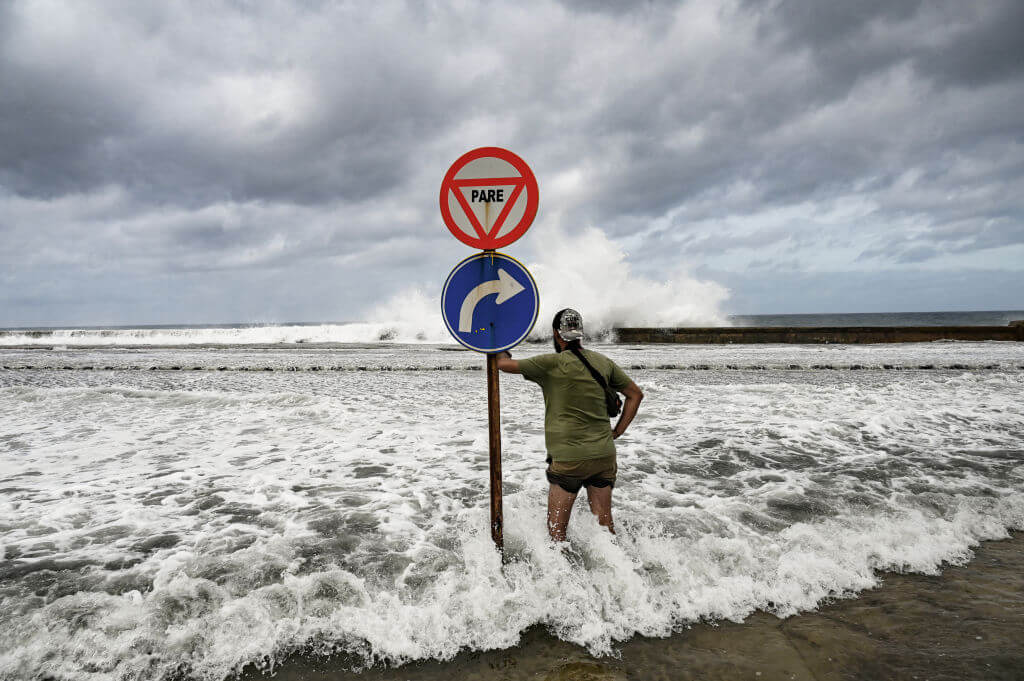 A man looks at waves crashing against the promenade in Havana due to the passage of Hurricane Milton on October 9, 2024.