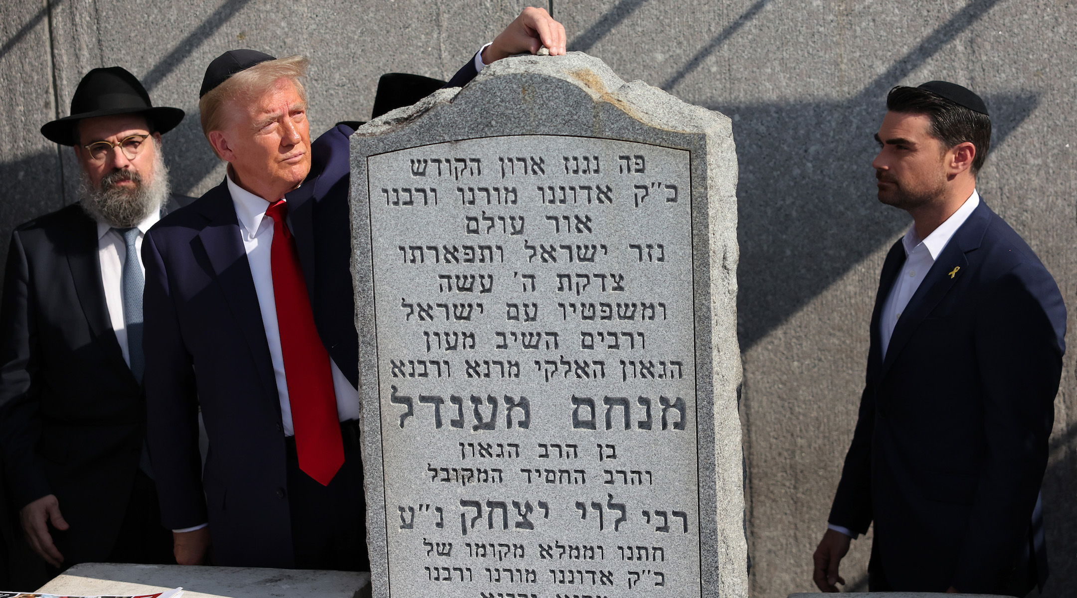 Republican presidential nominee Donald Trump, places a rock on the gravestone of Rabbi Menachem Mendel Schneerson as Ben Shapiro watches at Ohel Chabad Lubavitch on October 7, 2024 in New York City. (Michael M. Santiago/Getty Images)