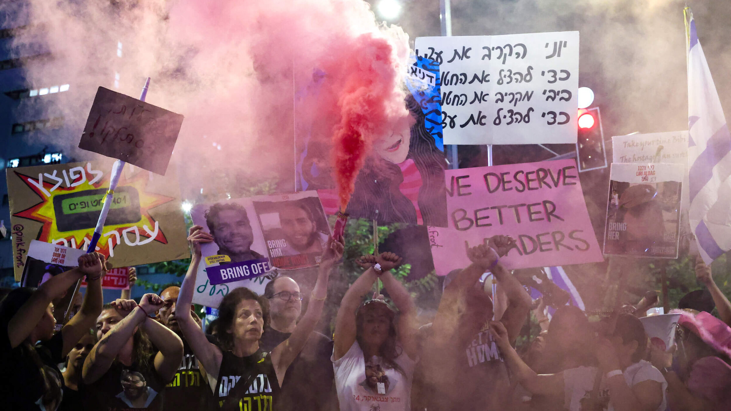 Demonstrators hold placards and set off smoke bombs during an anti-government protest in Israel. 