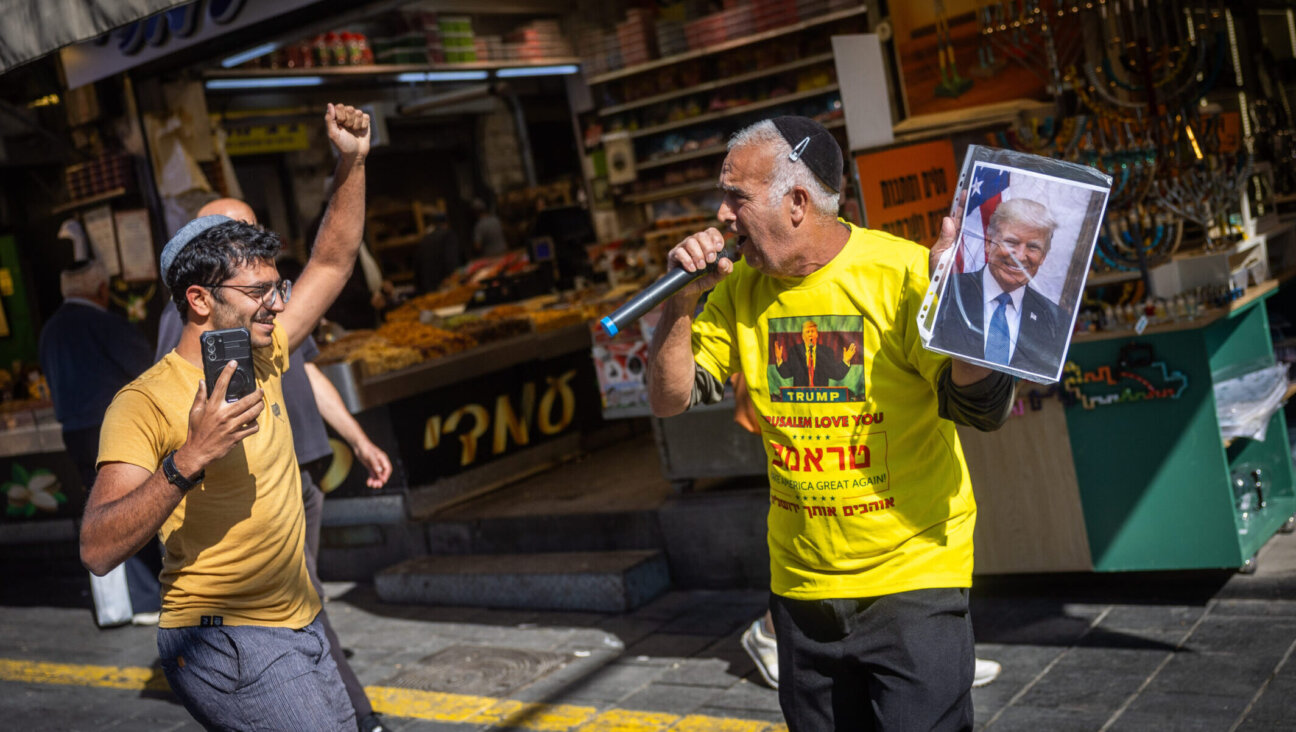 A supporter of Republican presidential nominee and former U.S. President Donald Trump dance with Israelis at the Mahaneh Yehudah Market in Jerusalem, on Nov. 4, 2024. (Yonatan Sindel/Flash90)