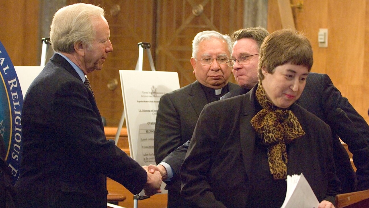 Felice Gaer, at right, then chair of the U.S. Commission on International Religious Freedom, takes part in a news conference presenting its report card on the two-year-old “Report on Asylum Seekers in Expedited Removal,” Feb. 7, 2007. At left, Sen.  Joseph Lieberman (D-Conn.) shakes hands with Rep. Chris Smith (R-N.J.) as Bishop Ricardo Ramirez, commissioner of the USCIRF, looks on. (Douglas Graham/Roll Call/Getty Images)