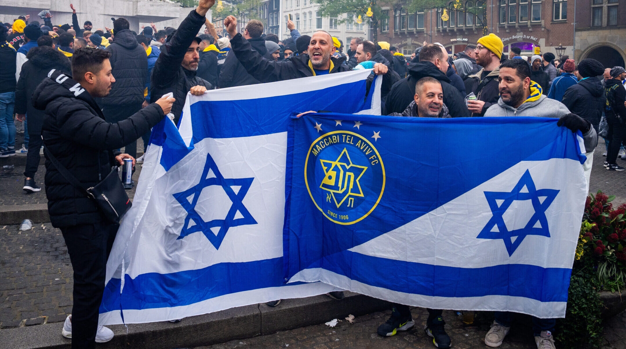 Supporters of Maccabi Tel Aviv hold Israeli and team flags at Dam Square ahead of the Europa League football match between Ajax and Maccabi Tel Aviv, Nov. 7, 2024. (Jeroen Jumelet / ANP / AFP via Getty Images)