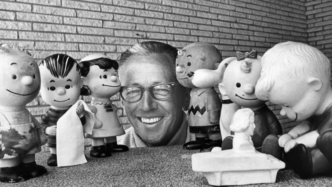 Charles M Schultz surrounded by rubber doll replicas of the characters in his <i>Peanuts</i> comic strip in 1966.