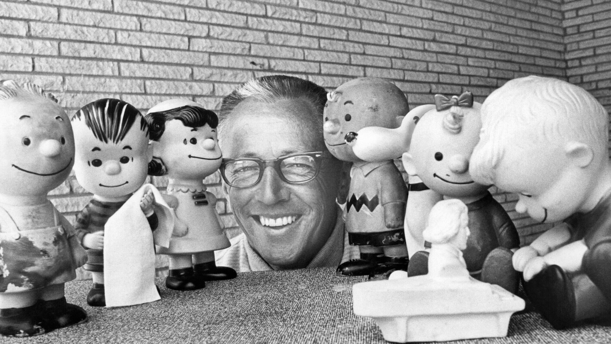 Charles Schultz surrounded by rubber doll replicas of the characters in his <i>Peanuts</i> comic strip in 1966.