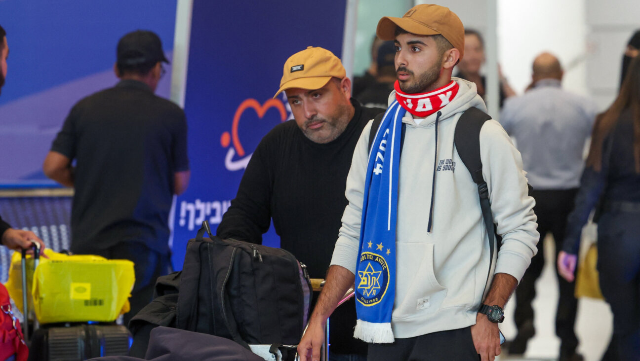 A fan of the Israeli Maccabi soccer team walks through David Ben-Gurion airport after Israeli officials evacuated Israelis from Amsterdam Thursday night.