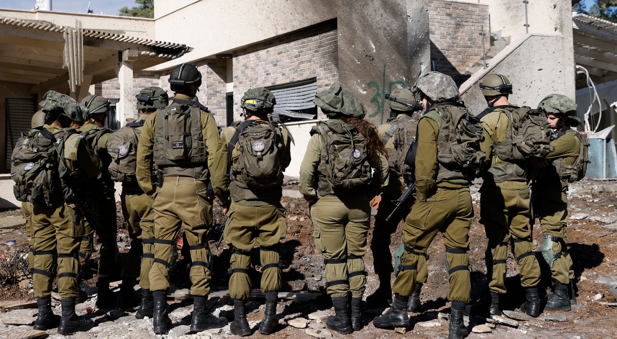 Israeli army forces stand outside a house that was hit by rockets fired by Hezbollah from Lebanon in the northern Israeli border town of Kiryat Shmona on Nov. 26, 2024. (Jalaa Marey/AFP via Getty Images)