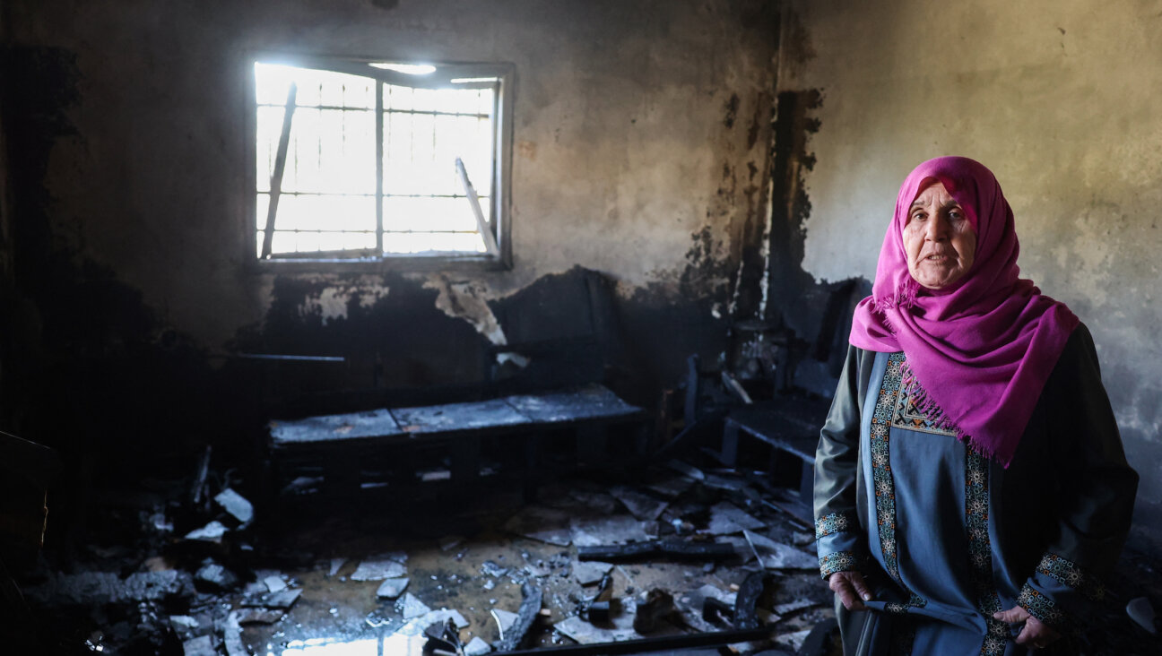 A Palestinian woman inspects her damaged house following an attack earlier by Israeli settlers in the West Bank town of Huwara, south of Nablus, on Dec. 4. 