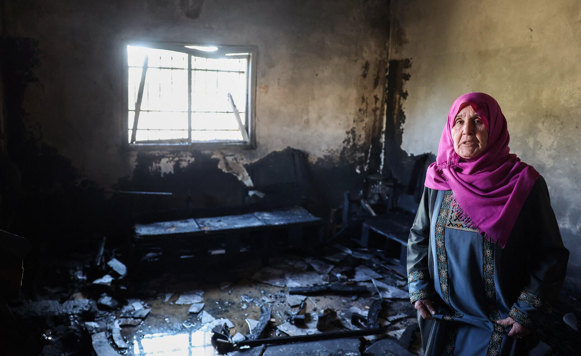 A Palestinian woman inspects her damaged house following an attack earlier by Israeli settlers in the West Bank town of Huwara, south of Nablus, on Dec. 4. 