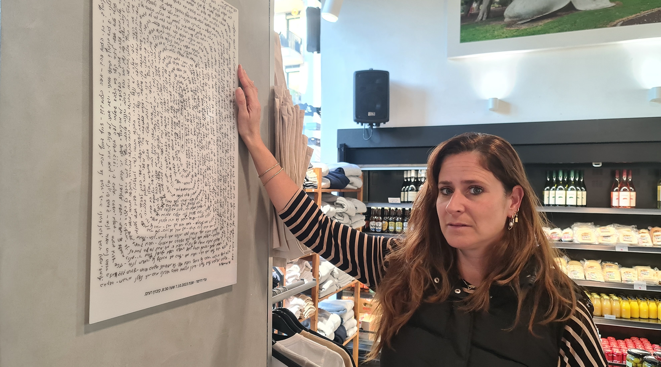 Reut Karp, whose ex-husband was murdered on Oct. 7, 2023, in front of their children, shows off art connected to the massacre at Cafe Otef, the Tel Aviv coffee shop she manages in his honor. (Deborah Danan)