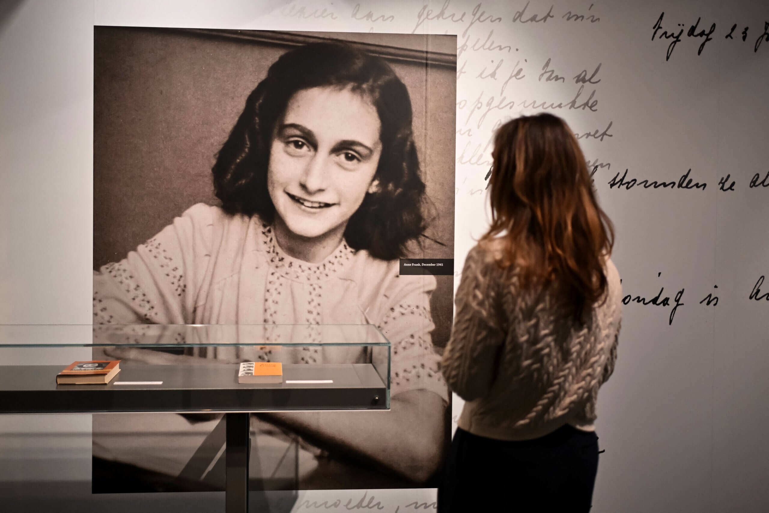 A person looks at a picture of Anne Frank at  "Anne Frank The Exhibition" at the Center for Jewish History.