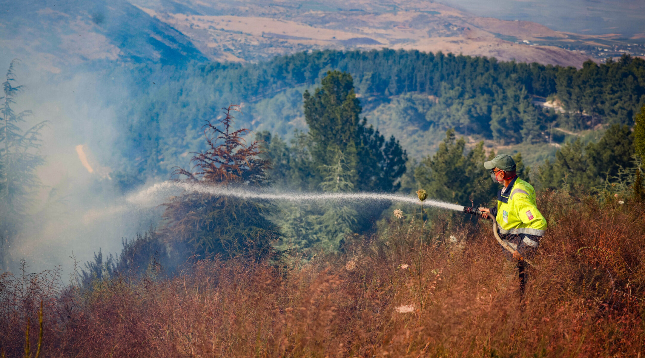 Israeli firefighters try to extinguish a fire that started from a fragments of an interception missile at the Biriya Forest in northern Israel, June 4, 2024. (David Cohen/Flash90)