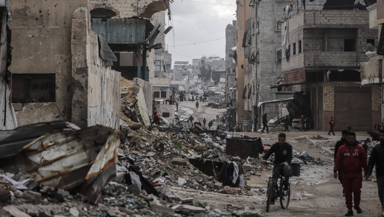 Returning Palestinians pass destroyed buildings in Gaza City during the Israel-Hamas ceasefire on Feb. 7. 