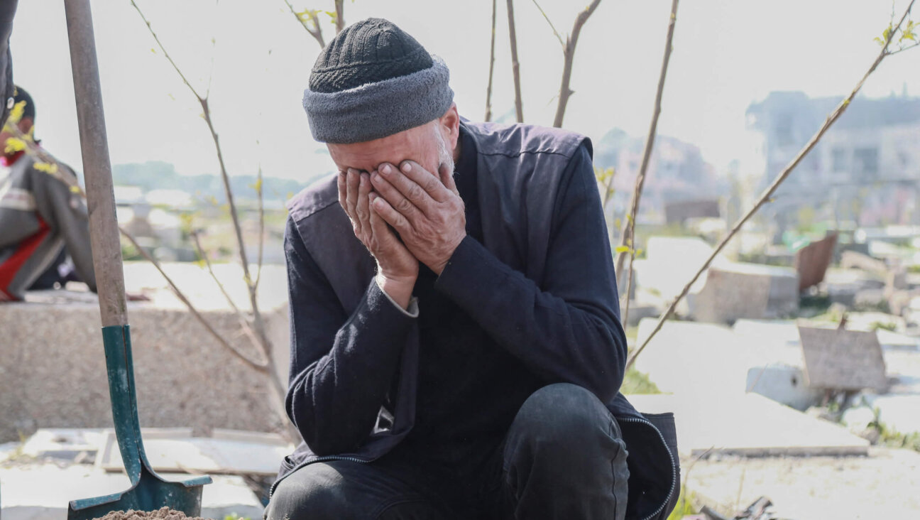 An elderly man covers his face while crying beside a grave in the Fallujah cemetery in the northern Gaza Strip on Feb. 3 