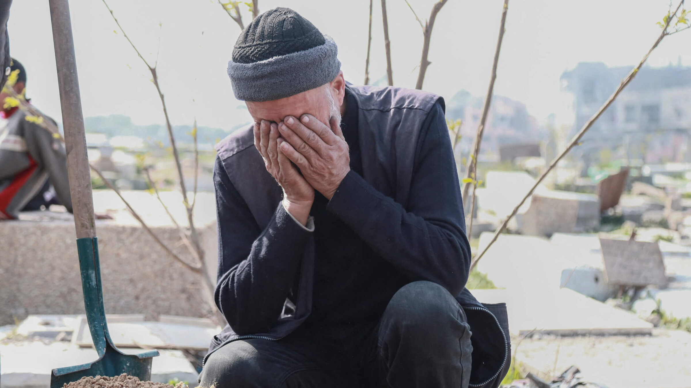 An elderly man covers his face while crying beside a grave in the Fallujah cemetery in the northern Gaza Strip on Feb. 3 